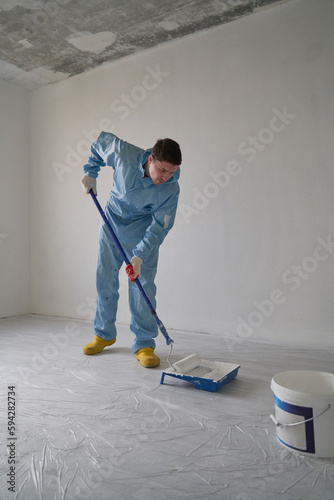 Man paints the ceiling with a roller