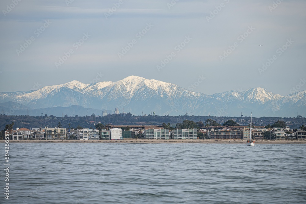 Beach and DTLA skyline with snow capped mountains