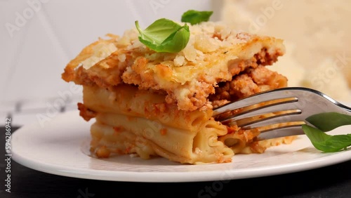 Greek Pastitsio is a Greek version of Lasagna. layer of tubular pasta beef ragu and béchamel sauce. Pasta with cheese and basil leaf on a plate photo