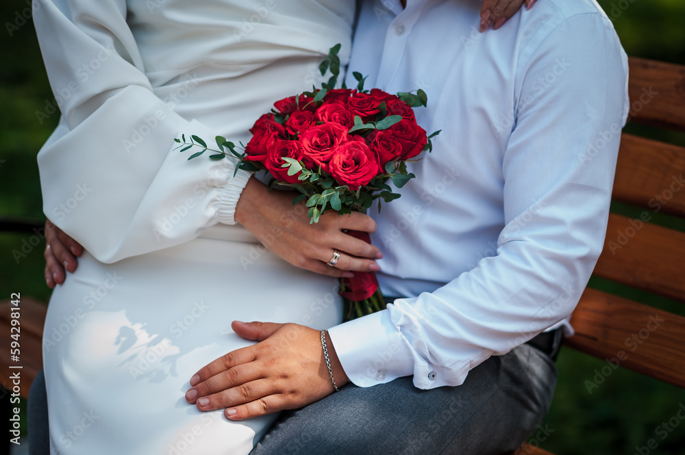 Bouquet of red roses in the hands of the bride. Bridal bouquet in woman's hands Bouquet of red roses in the hands of the bride. Bridal bouquet in woman's hands