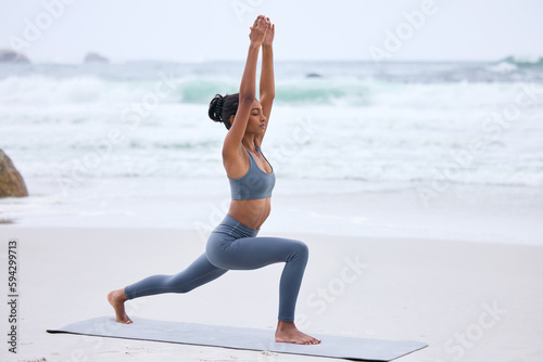 Fototapeta Naklejka Na Ścianę i Meble -  Reaching her fitness goals. Full length shot of an attractive young woman practicing yoga on the beach.