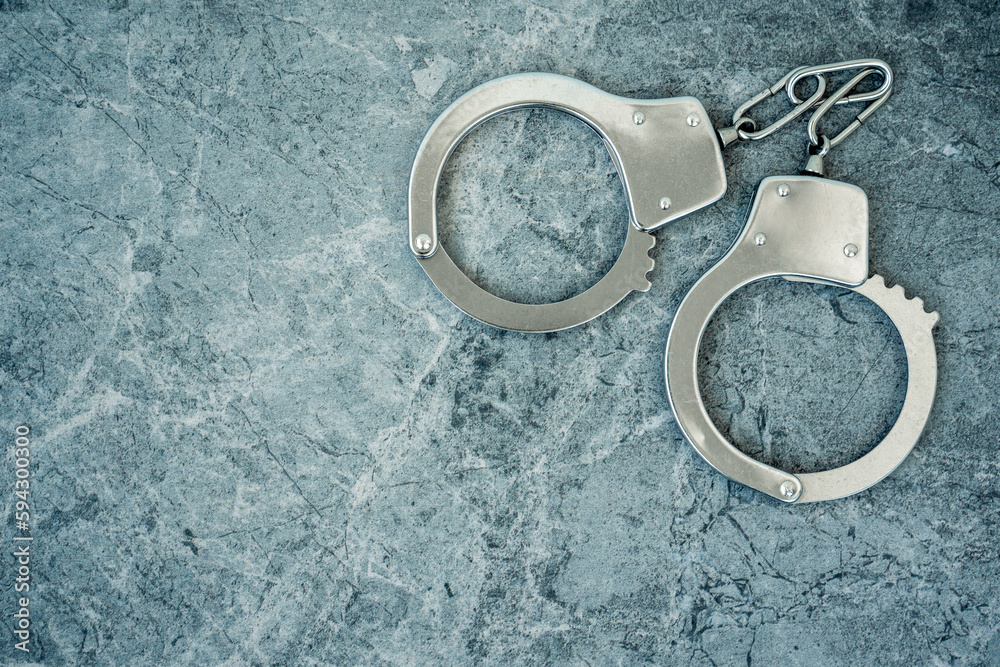 Closed handcuffs on the cement background Closed handcuffs on the cement background