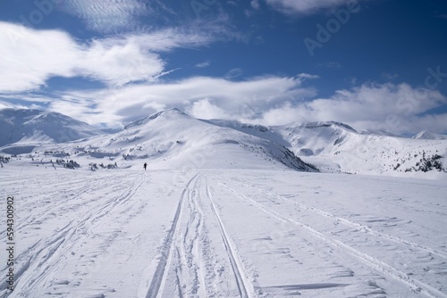 Idyllic cross-country ski trail set against a majestic backdrop of snow-capped mountains.