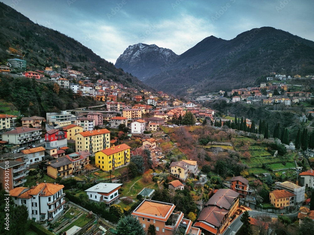 Drone view of Lake Como surrounded by a town and mountains in the evening in Italy