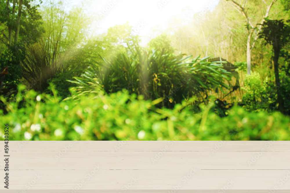Wooden table top with natural green blurred background or various leaves, fresh bright sunlight, product empty concept.