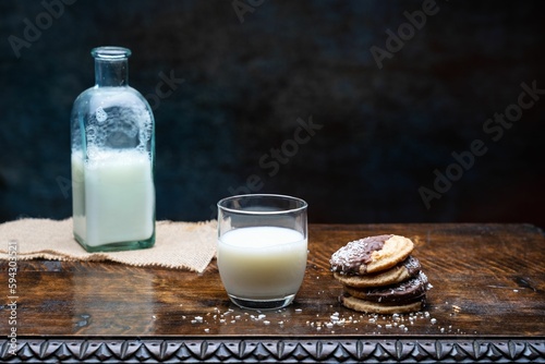 Closeup shot of a glass of milk and cookies on the table