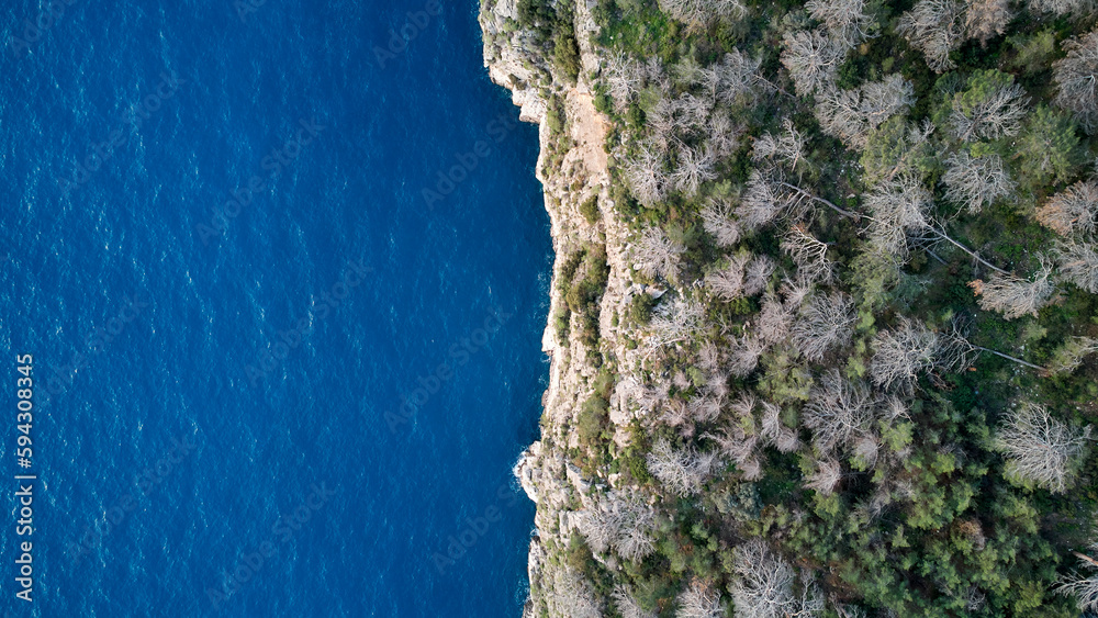 A breathtaking view of the azure sea from atop a cliff in Faralya, Turkey - untouched beauty in nature.