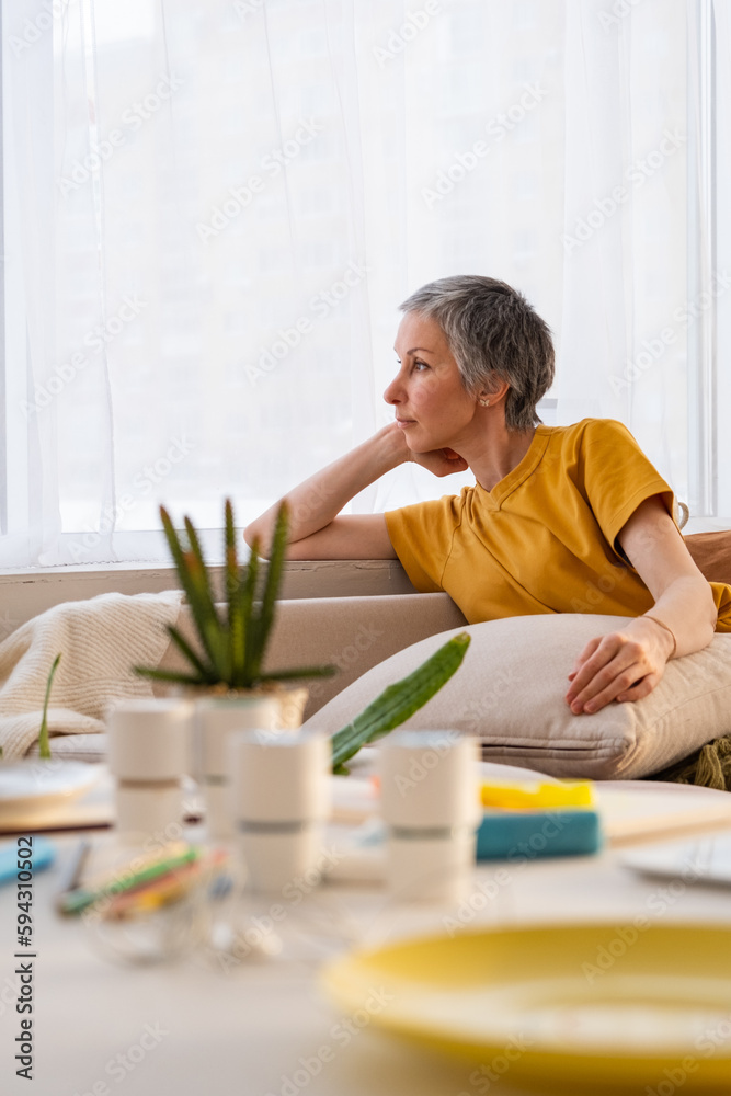 Calm mature woman relaxing at home on couch Calm mature woman relaxing at home on couch