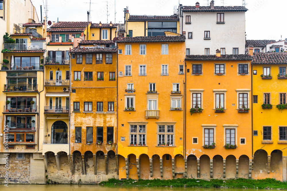 Beautiful architecture of Firenze, Tuscany, Italy, beautiful yellow colors above the water of Arno river