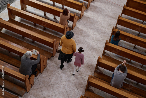 High angle view of believer people praying while sitting on benches in church during ministration
