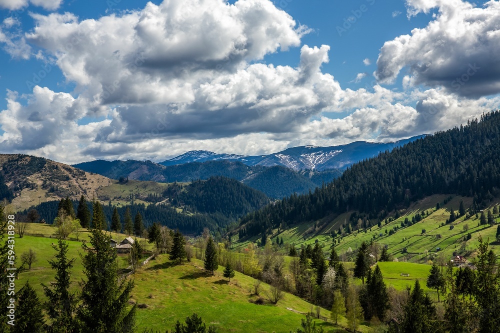 Beautiful view of green hills with lush woods against the background of the cloudy blue sky. Beautiful view of green hills with lush woods against the background of the cloudy blue sky.