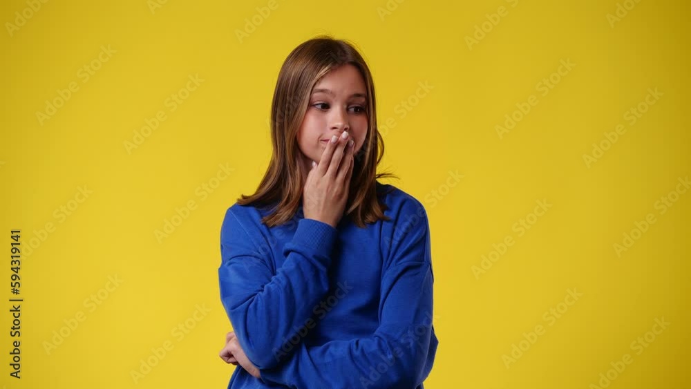 4k video of one girl planning something and holds his hands on to his chin and lips over yellow background. 4k video of one girl planning something and holds his hands on to his chin and lips over yellow background.