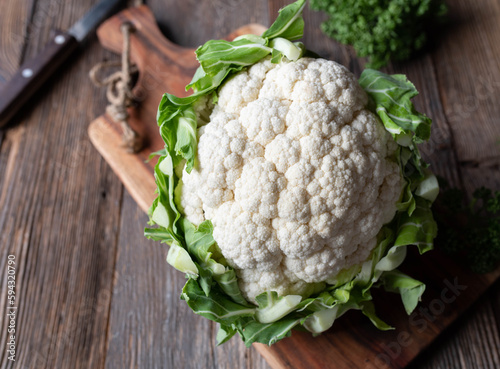 Cauliflower with leaves on wooden table