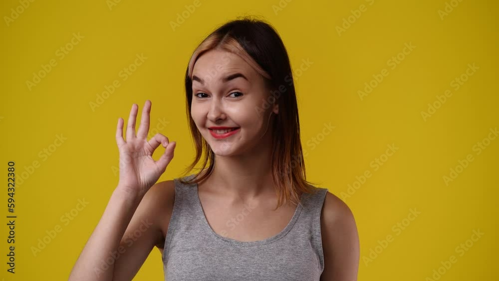 4k slow motion video of one girl showing thumbs up and smiling over yellow background. 4k slow motion video of one girl showing thumbs up and smiling over yellow background.