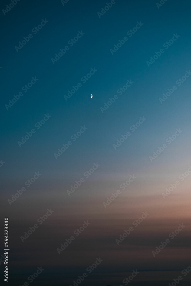 Vertical shot of a sky with the moon at sunset Vertical shot of a sky with the moon at sunset