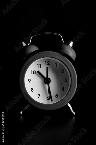 Small alarm clock on a black background.