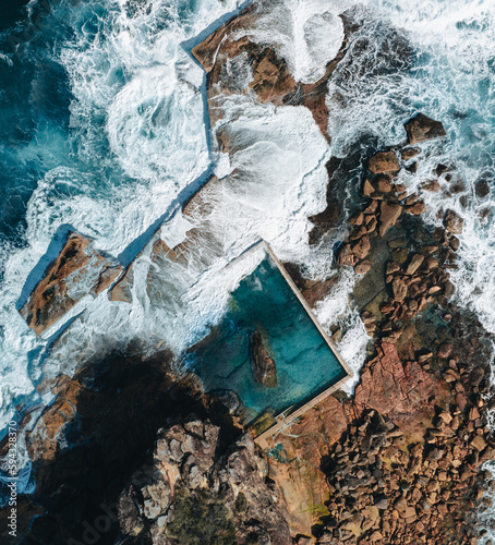 Photography Aerial view early morning light with ocean waves flowing over rocks around North Curl Curl ocean rock pool during storm