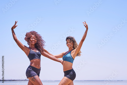 Happy bikini two women jumping of joy and success on perfect white sand beach on tropical vacation. Holiday girls with sexy slim suntan body running of freedom 