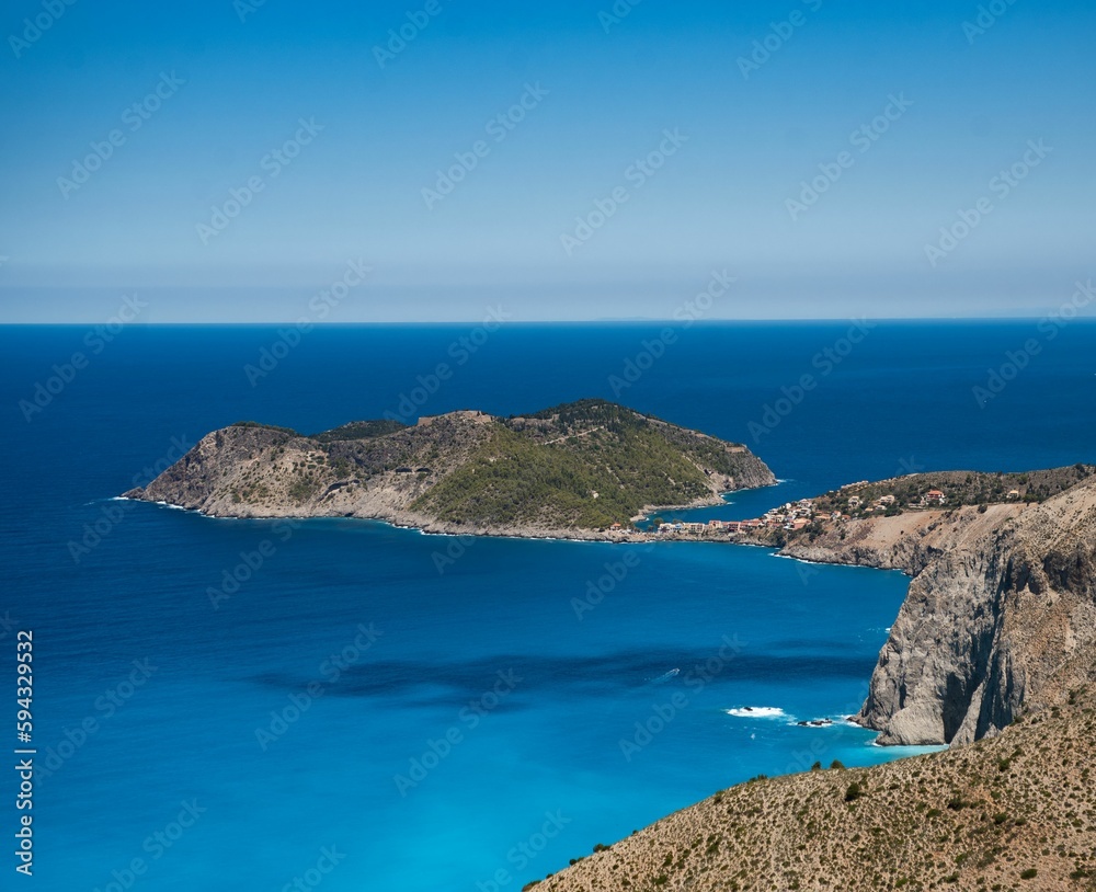 a small island sits near the water in a blue sea