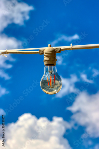 Close up of a light bulb with sky with clouds in the background. I had an idea. Wallpaper, background, texture