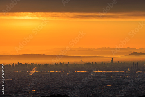 Intense orange glow over smoggy industrial city at sunrise