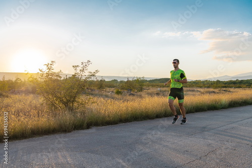 Triathlete in professional gear running early in the morning, preparing for a marathon, dedication to sport and readiness to take on the challenges of a marathon.  © .shock