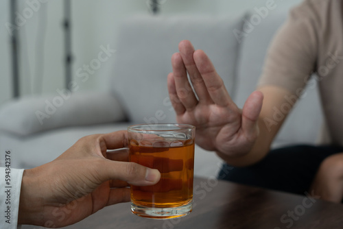man refuses say no and avoid to drink an alcohol whiskey , stopping hand sign male, alcoholism treatment, alcohol addiction, quit booze, Stop Drinking Alcohol. Refuse Glass liquor, unhealthy, reject.