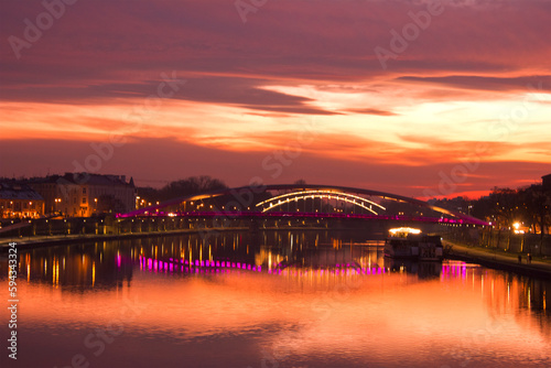 a purple sunset over the Vistula in Krakow. Cityscape with river, bridge and evening lights
