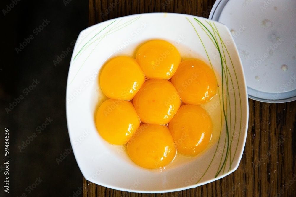 Top view of yellow egg yolks on a white plate