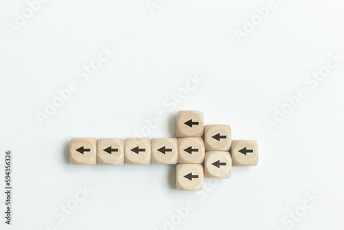 Fototapeta Arrow icon on wooden cubes with little arrow icons pointing opposite direction