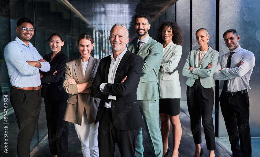 Obraz premium Multicultural business team headed by boss. Posing to camera cheerfully with crossed arms at the office.