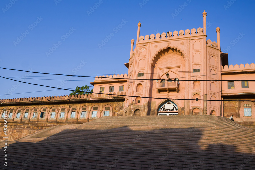Fototapeta premium Entrance gate of Taj-ul masjid, the largest mosque in india. The historical monument was built with red sandstone in indo-islamic architecture style. Photo taken against blue sky.