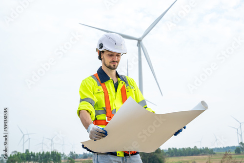 Group of engineers are working with a blueprint in wind turbine farm,Wind power station,Renewable and clean energy concept.