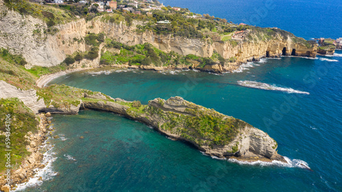Aerial view on the Trentaremi bay of Posillipo, a district of Naples, Italy. There is a small empty beach in a cove. The coast overlooks the Mediterranean Sea.