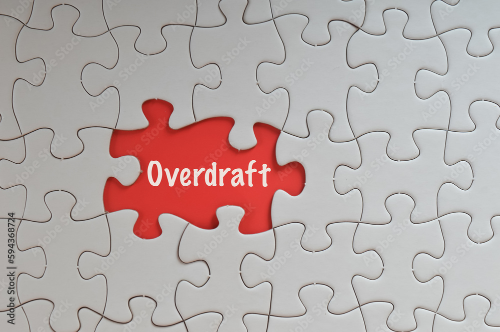 Missing jigsaw puzzle with text OVERDRAFT isolated on a red background. Missing jigsaw puzzle with text OVERDRAFT isolated on a red background.