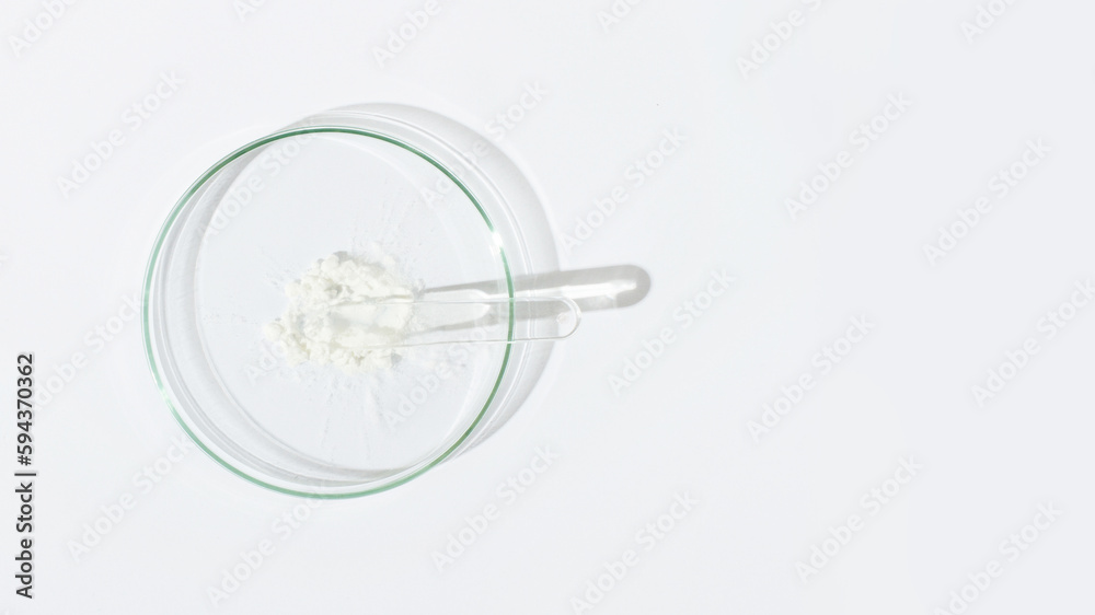 White powder in a Petri dish. Cocaine, cannabinoid, medicinal powder, antibiotic. lab, research. White powder in a Petri dish. Cocaine, cannabinoid, medicinal powder, antibiotic. lab, research.