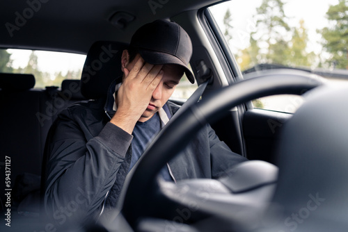 Tired man in car. Sleepy drowsy driver, fatigue. Driving and sleeping in vehicle. Exhausted, bored or drunk person. Serious upset man with stress, despair, anxiety or melancholy. Problem in traffic. © terovesalainen