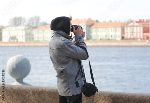 Male photographer on the river embankment, Admiralteyskaya Embankment, St. Petersburg, Russia, April 2023 photo