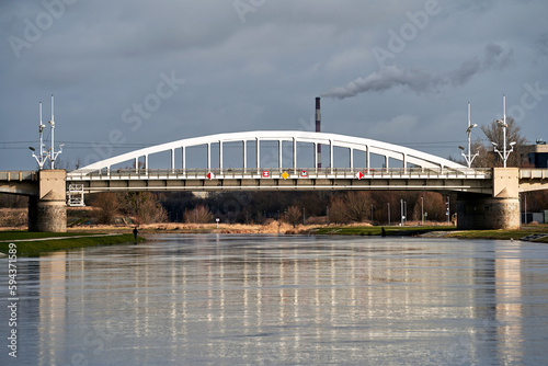 The steel structure of the bridge over the Warta River and smoke from a mudflat chimney in Poznan