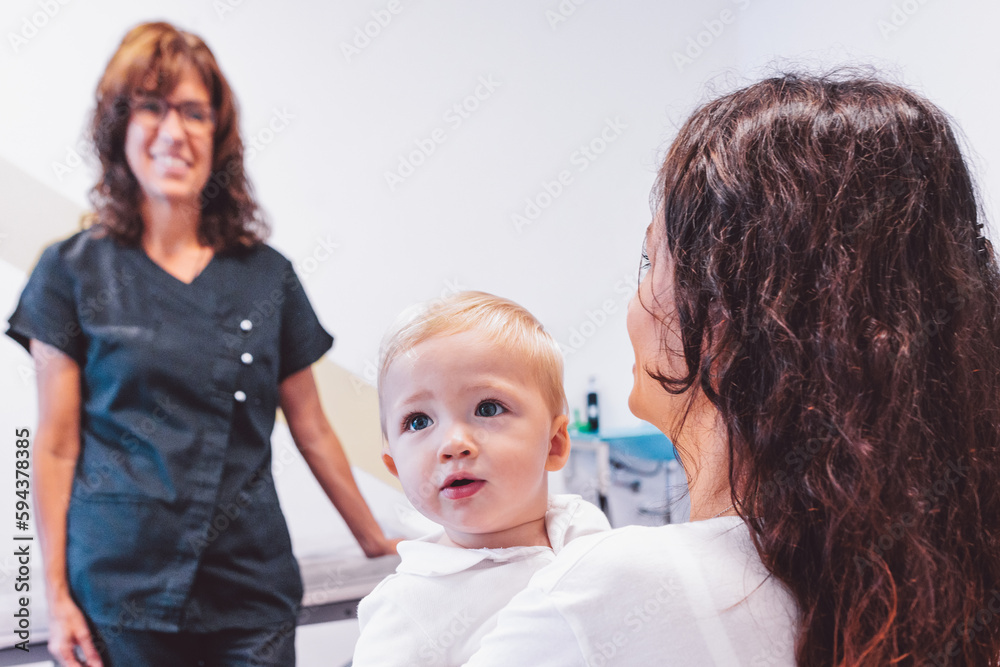 Smiling doctor speaking to mother with child