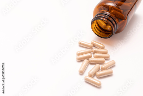 View From Above Capsules OF Slippery Elm, Brown Glass Bottle On White Background. Herbal Supplement, Medication. Ulmus Fulva, Natural Remedy Concept. Horizontal, Top View, Copy Space
