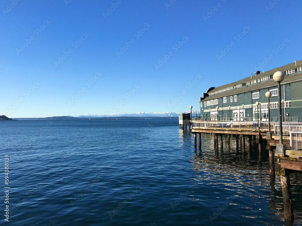 One of the covered piers downtown Seattle on a sunny day with the Olympic mountains in the background.