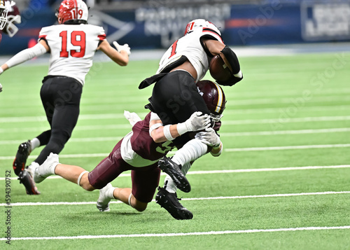 Young athletic young boys playing in a competitive game of tackle football and making incredible game winning plays