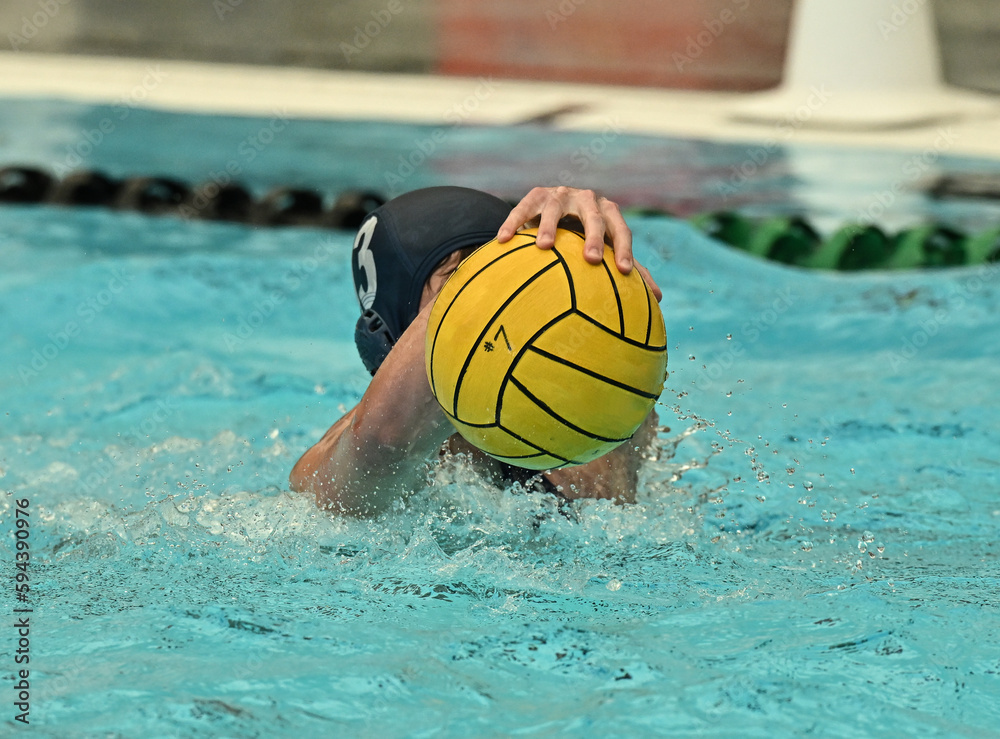 Young athletic swimmers competing in a swim meet and water polo