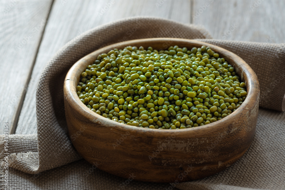 mung beans (Vigna radiata) , green mung beans in a wooden bowl on an old rustic table mung beans (Vigna radiata) , green mung beans in a wooden bowl on an old rustic table