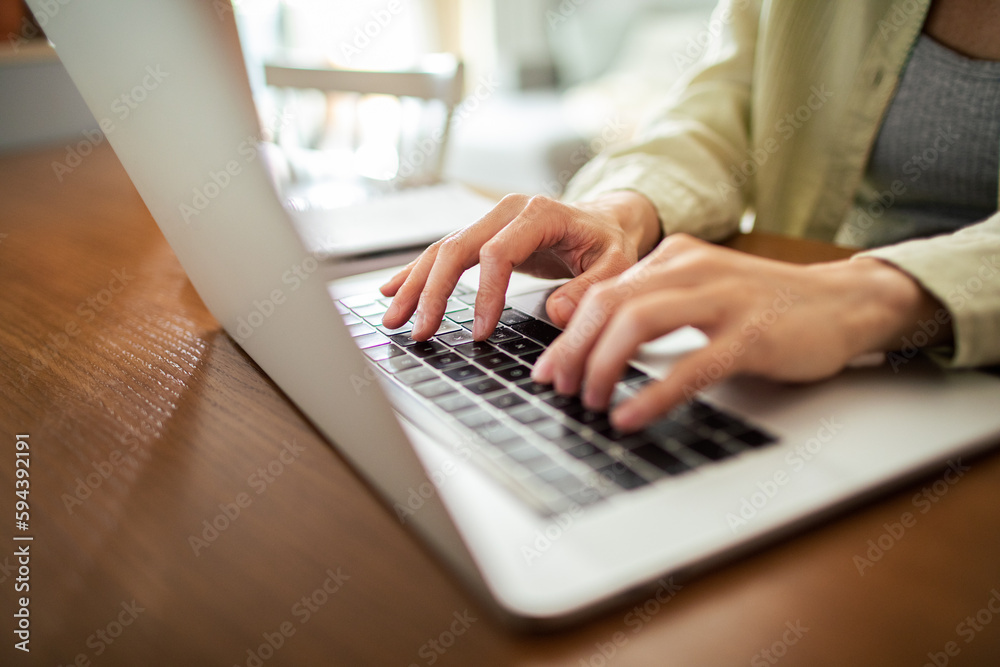 Young Japanese Woman working on a laptop in the kitchen Young Japanese Woman working on a laptop in the kitchen
