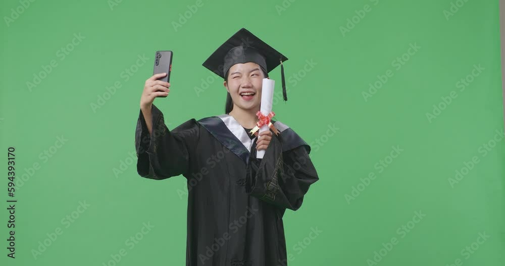 Asian Woman Student Graduates In Cap And Gown With Diploma Taking Photo
