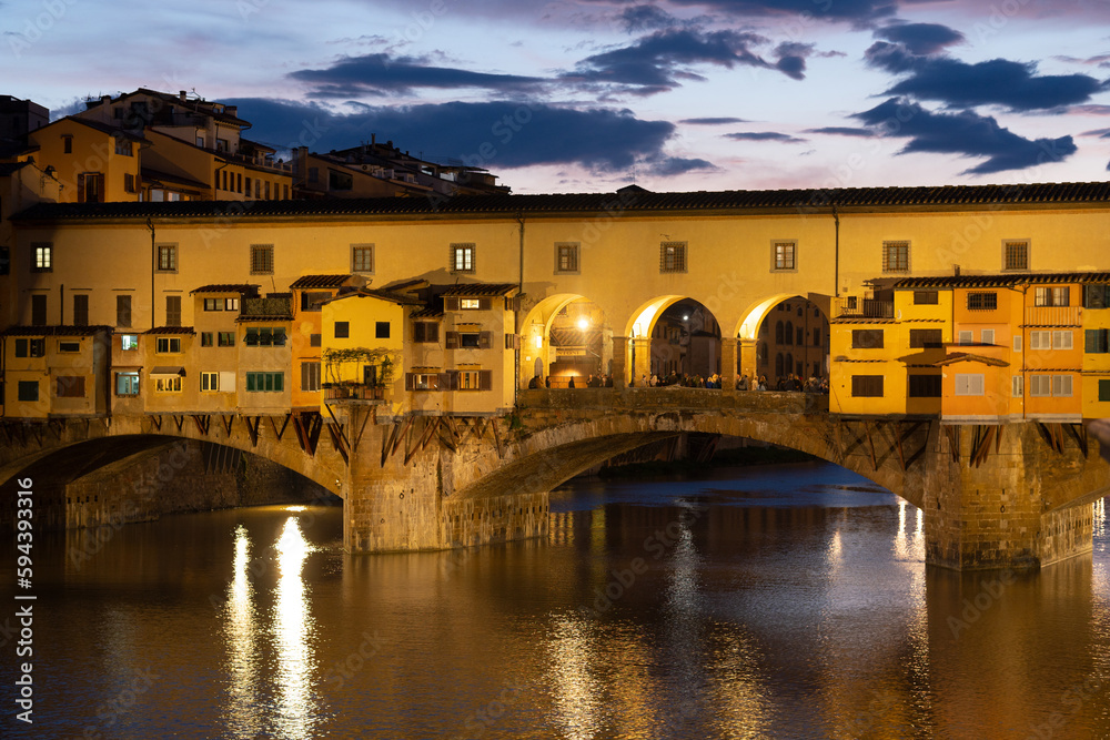 Beautiful architecture of Ponte Vecchio above Arno river, Firenze, Tuscany, Italy, Europe. Sunset evening clouds 