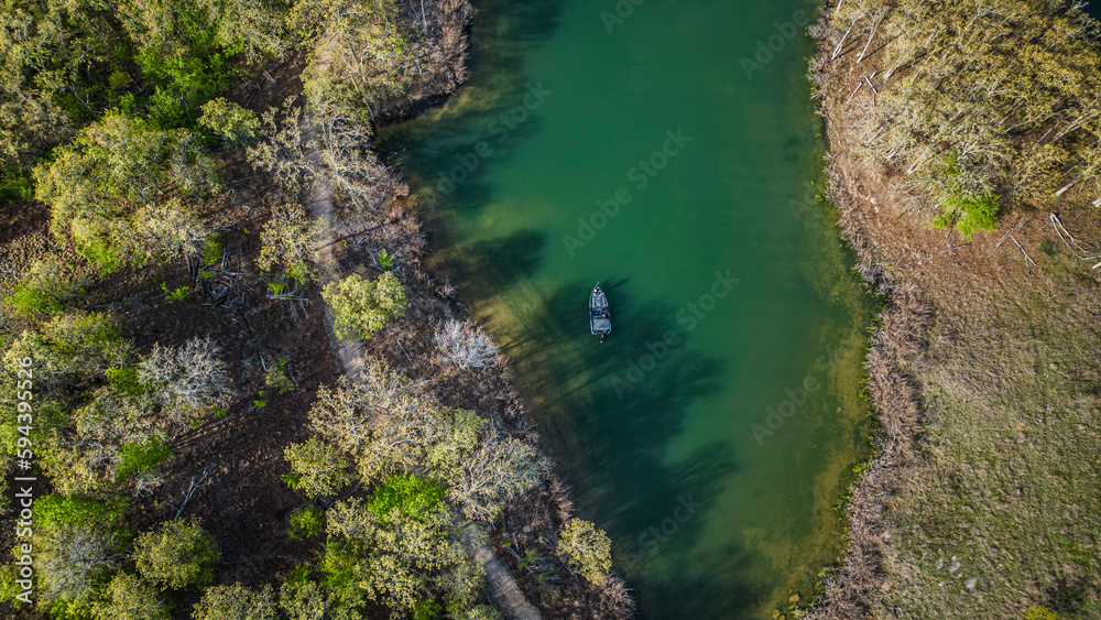 Fototapeta premium Bass boat fishing in back of creek in the spring