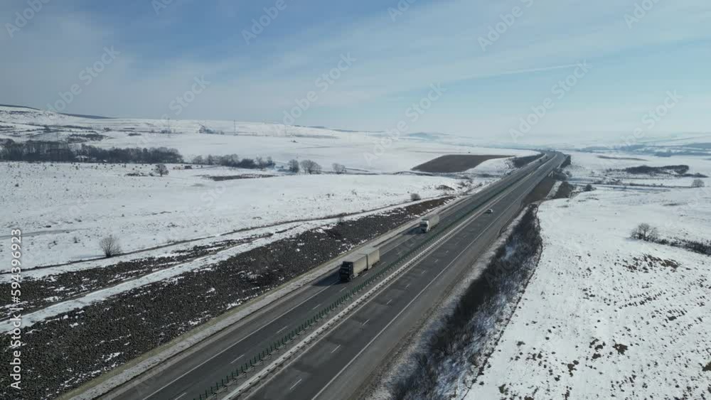 High-angle shot of traffic on the highway in winter, snowy fields around High-angle shot of traffic on the highway in winter, snowy fields around